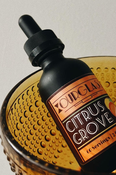 OURGLASS Delta-9 drops for drinks displayed in an amber glass bowl, ideal for creating Delta-9 beverages and thc tincture cocktails.