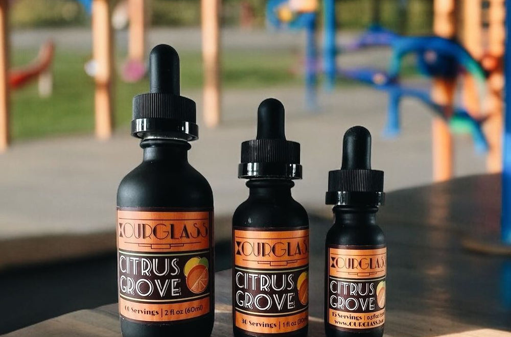 OURGLASS Delta-9 drops for drinks displayed outdoors, perfect for creating Delta-9 beverages and thc tincture cocktails for outdoor events.