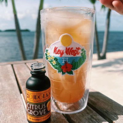 OURGLASS Delta-9 drops for drinks next to a Key West iced drink, ideal for creating Delta-9 beverages and thc-infused drinks by the beach.