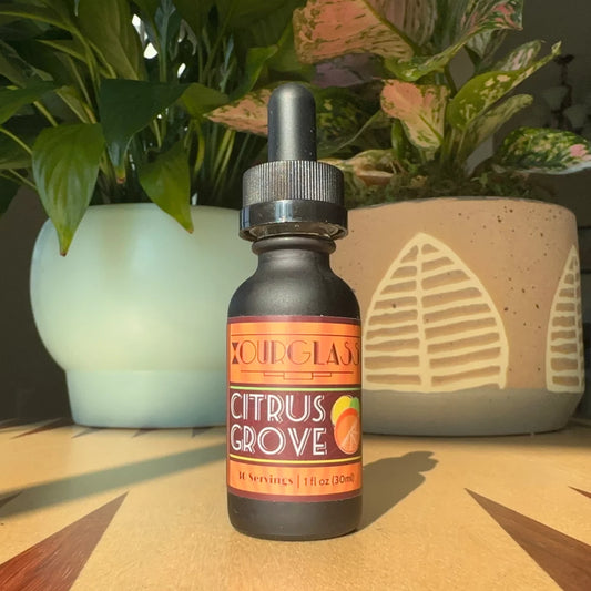 OURGLASS: A bottle of citrus grove delta 9 tincture displayed on a table, perfect for adding to drinks or enjoying as a thc tincture.