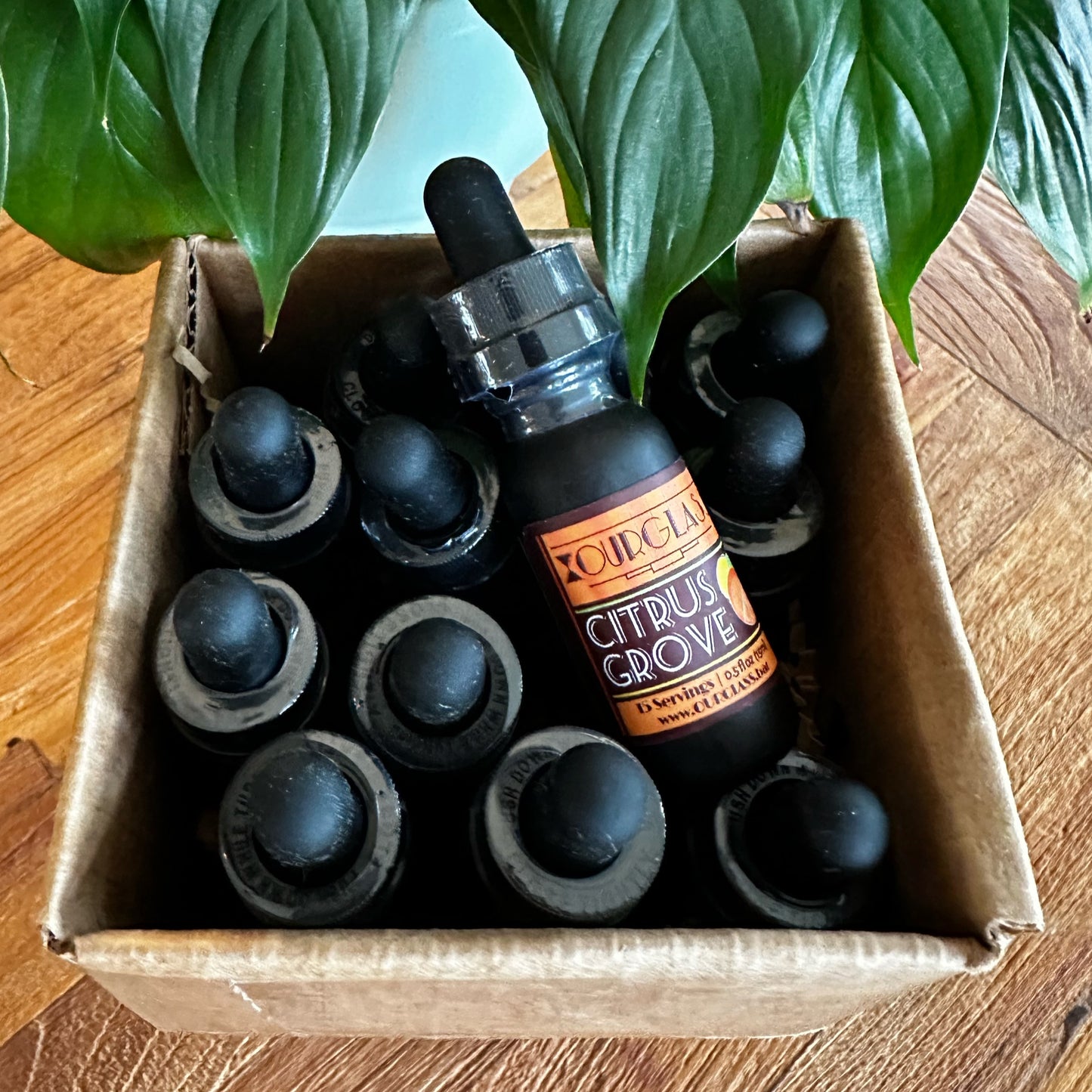 OURGLASS: A case of citrus grove flavored delta 9 drops for drinks, featuring a collection of thc tincture bottles ready for a refreshing experience.