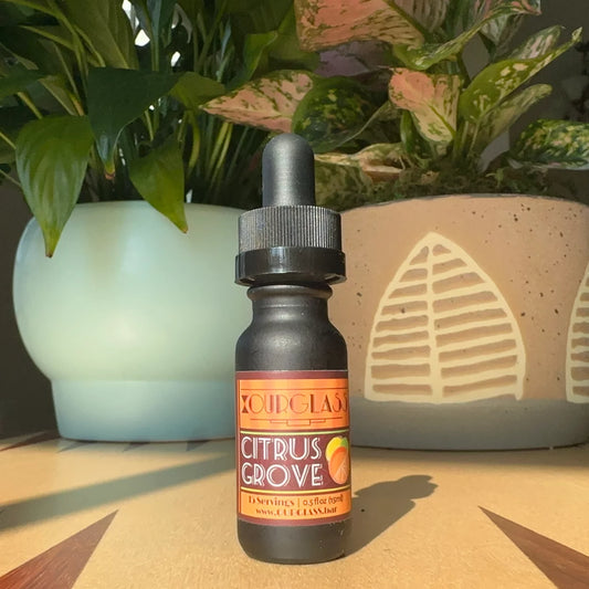 OURGLASS: A bottle of citrus grove delta 9 tincture displayed on a table, perfect for adding to drinks or enjoying as a thc tincture.