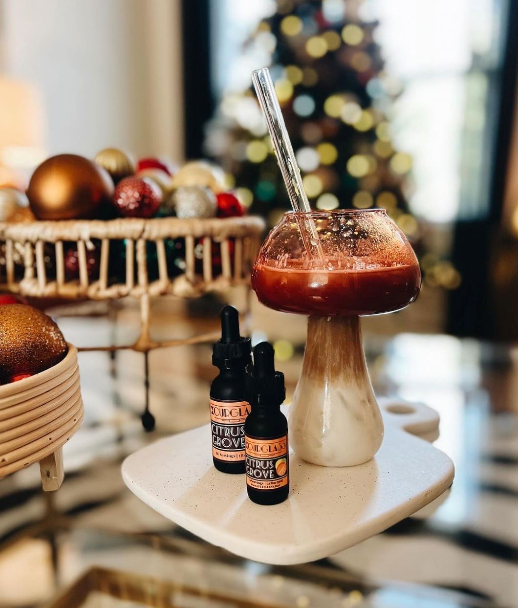 OURGLASS Citrus Grove delta 9 drops and thc tincture bottles beside a festive holiday drink, ideal for celebrating with thc beverages.